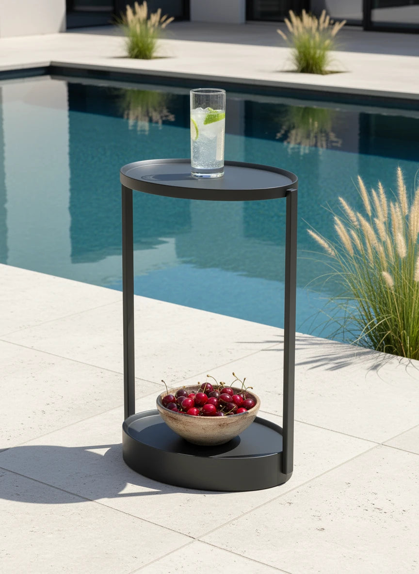Rauma durchbrochener Couchtisch - Aluminium pulverbeschichtet, steht elegant auf Patio, mit Glas Limonade oben und Schale Kirschen unten, neben Pool im Hintergrund.