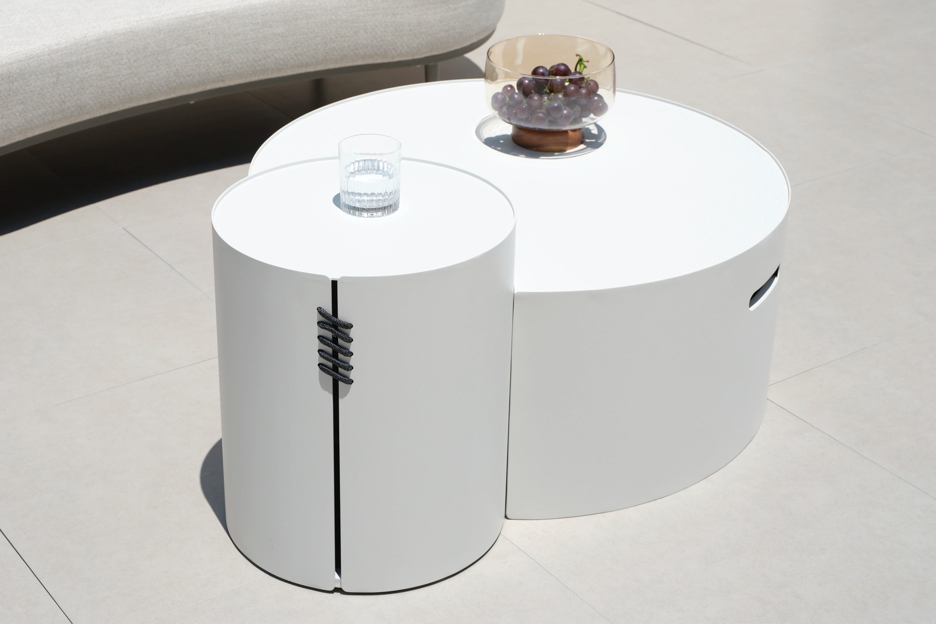 Aluminium Rund-Solarleuchte mit Solarlampe auf einem weißen runden Tisch, neben einer Schale mit Trauben. Ideal für stilvolle, nachhaltige Outdoor-Gestaltung von Finqa GmbH.