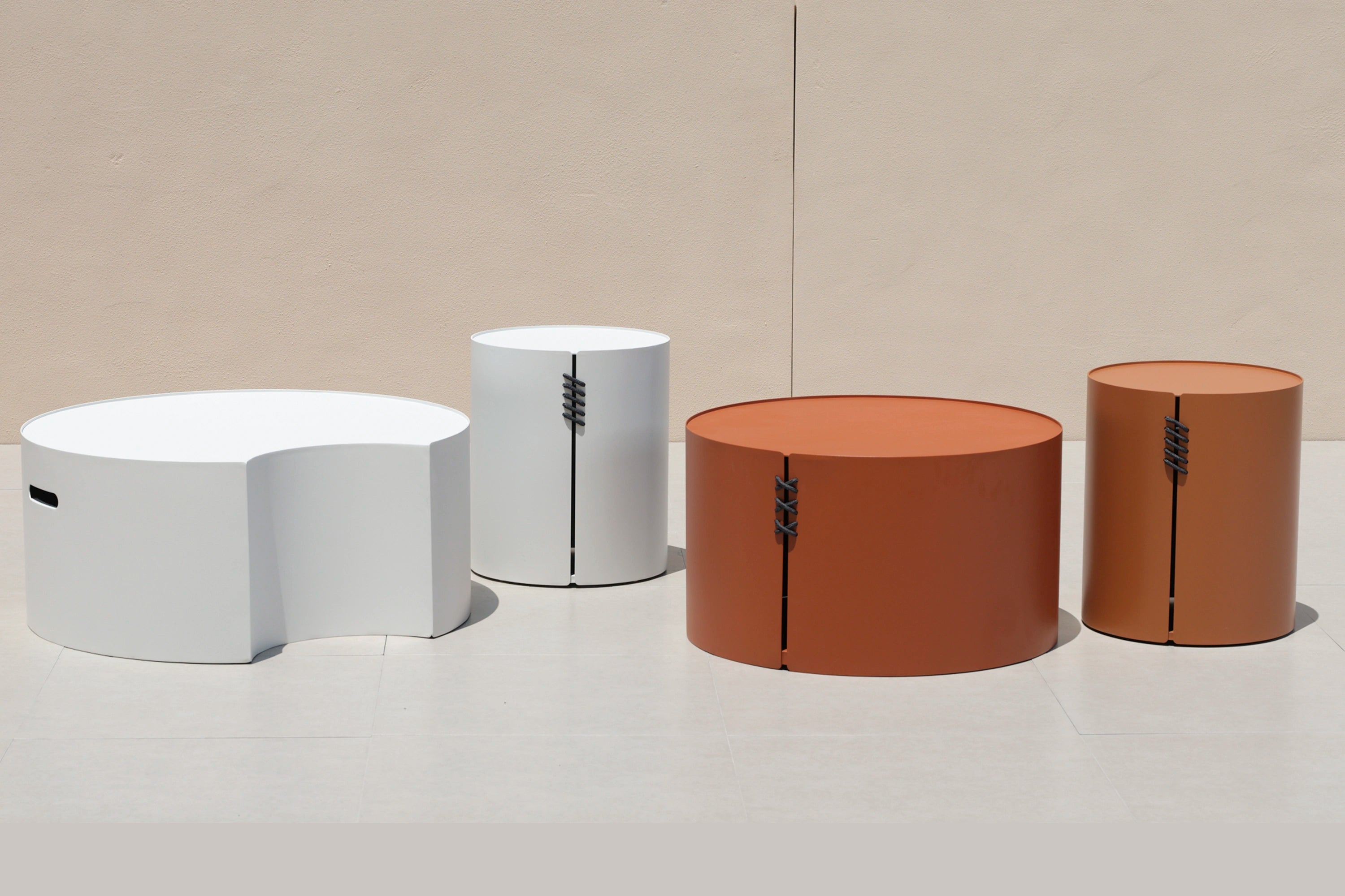 Aluminium-Solarleuchte mit runder Form und Solarlampe, erkennbar an schwarzen Riemen, auf einem weißen Tisch platziert. Passend zu Finqas modularen, stilvollen Outdoor-Designs für Gärten und Terrassen.
