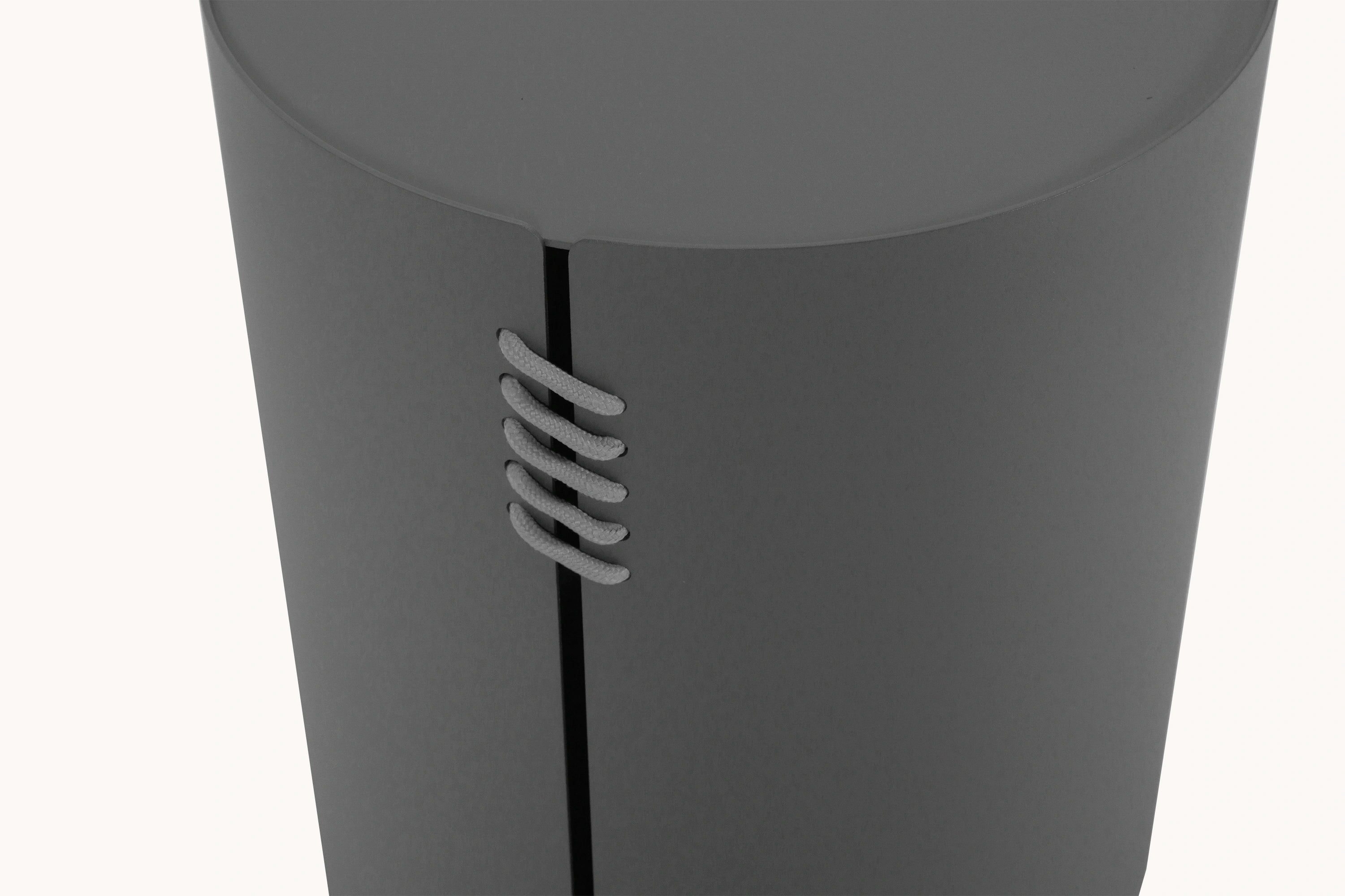 Aluminium Rund-Solarleuchte mit Solarlampe zeigt eine Nahaufnahme eines grauen Zylinders und geflochtenen Strukturelements, passend zu Finqa GmbHs Fokus auf stilvolle, modulare Outdoor-Lösungen.