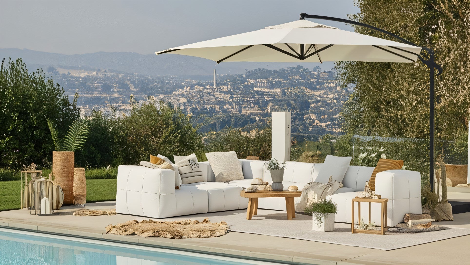 Marshmallow Modular Sofa Set (6-Sitzer) neben einem Pool mit weißem Tisch und großen Sonnenschirm, perfekt für stilvolle, nachhaltige Outdoor-Entspannung auf Terrassen oder in Gärten.