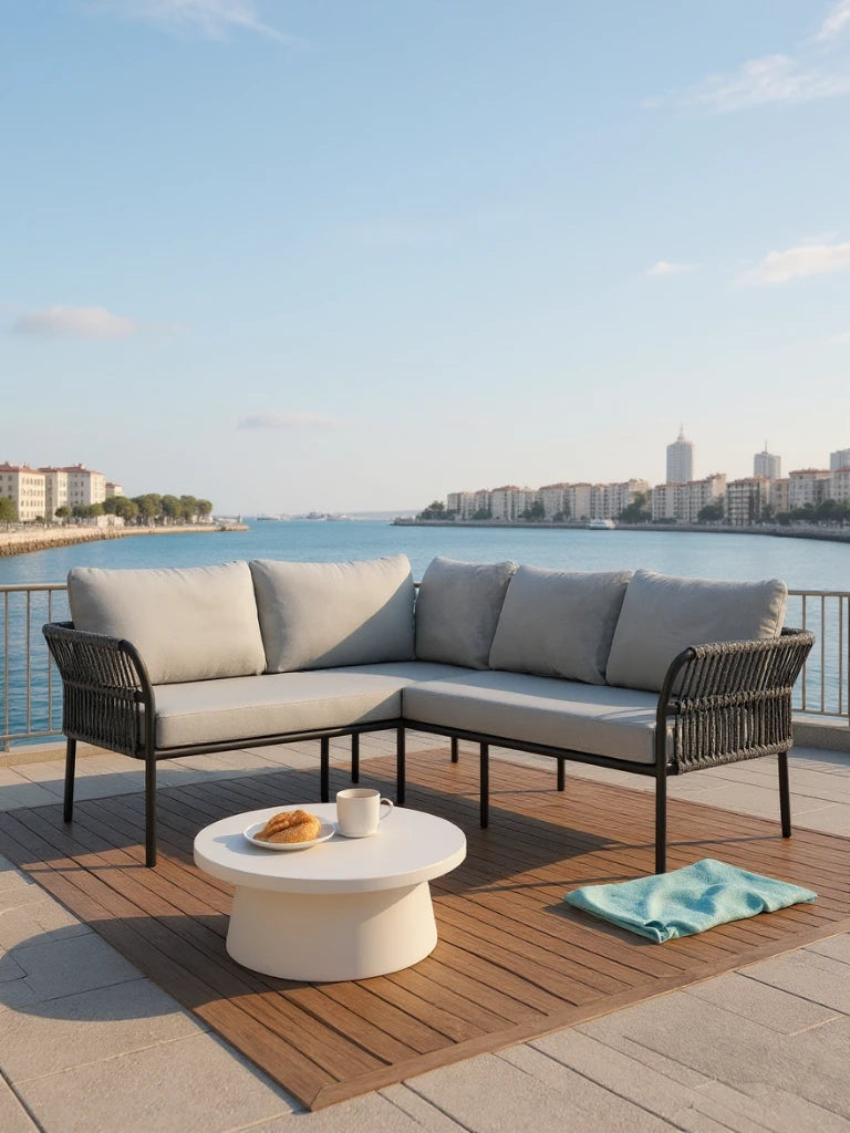 Malaga Garten Ecklounge Set (4-Sitzer) mit L-förmigem Sofa aus hellgrauen Kissen, schwarzem Metallrahmen auf Holzmatte, rundem weißem Tisch mit Tasse und Gebäck, ideal für stilvolle Terrassengestaltung.