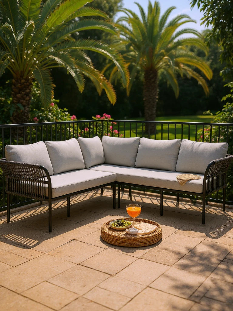Malaga Garten Ecklounge Set (5-Sitzer) auf Terrasse: L-förmiges Sofa aus Aluminium und Zugbändern mit grauen Kissen, begleitet von einem runden Tablett mit Getränk und Trauben auf Steinboden.