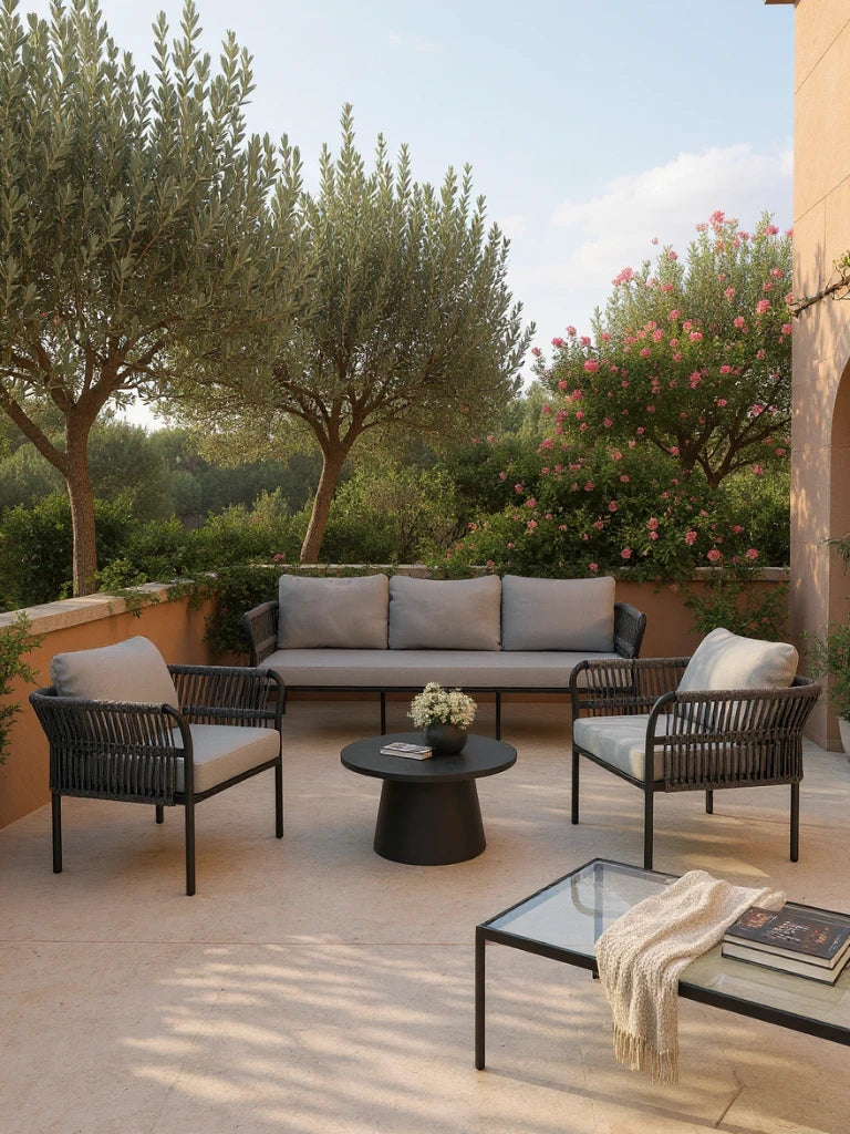 Malaga Garten Ecklounge Set (5-Sitzer) auf moderner Terrasse: Schwarzer Metallrahmen mit grauen Kissen, runde Tische, Olivenbäume im Hintergrund; stilvoll, langlebig und wetterfest, ideal für flexible Outdoor-Gestaltung.