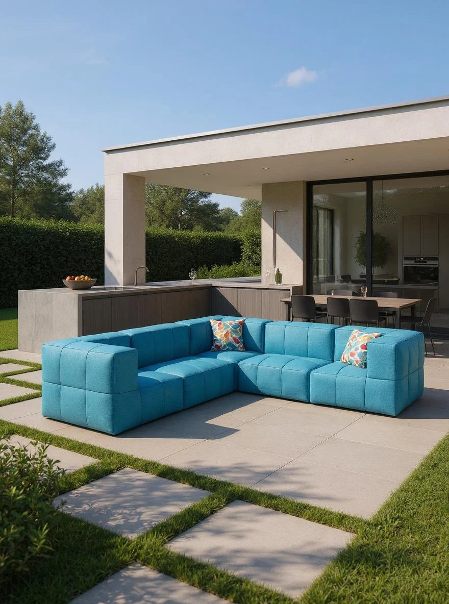 Modulares Garten-Lounge-Set Marshmallow, 5er-Set: L-förmiges, türkisfarbenes Sofa auf Betonplatten mit Grasstreifen, ergänzt durch bunte Kissen. Perfekt für moderne Outdoor-Bereiche, inspiriert von Finqas nachhaltigem Design.