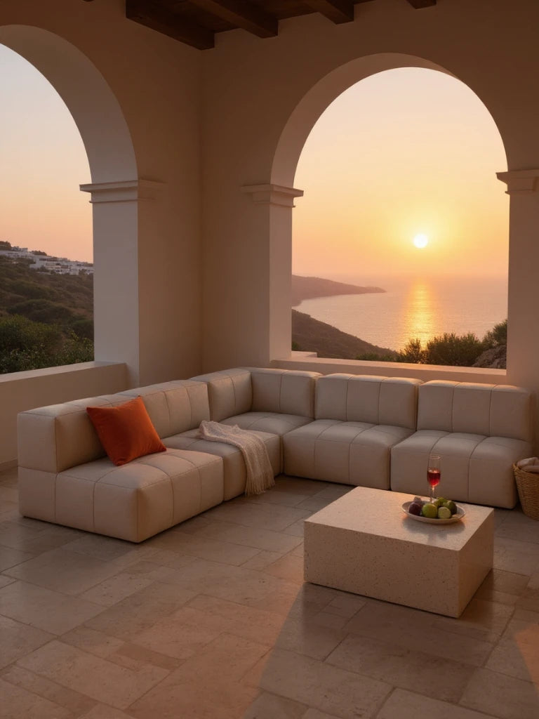 Modulares Garten-Lounge-Set Marshmallow, 5er-Set: Ein L-förmiges, modulares Sofa auf einer mediterranen Terrasse, mit einem rustfarbenen Kissen und Decke, vor einem Tisch mit Obst und Wein.