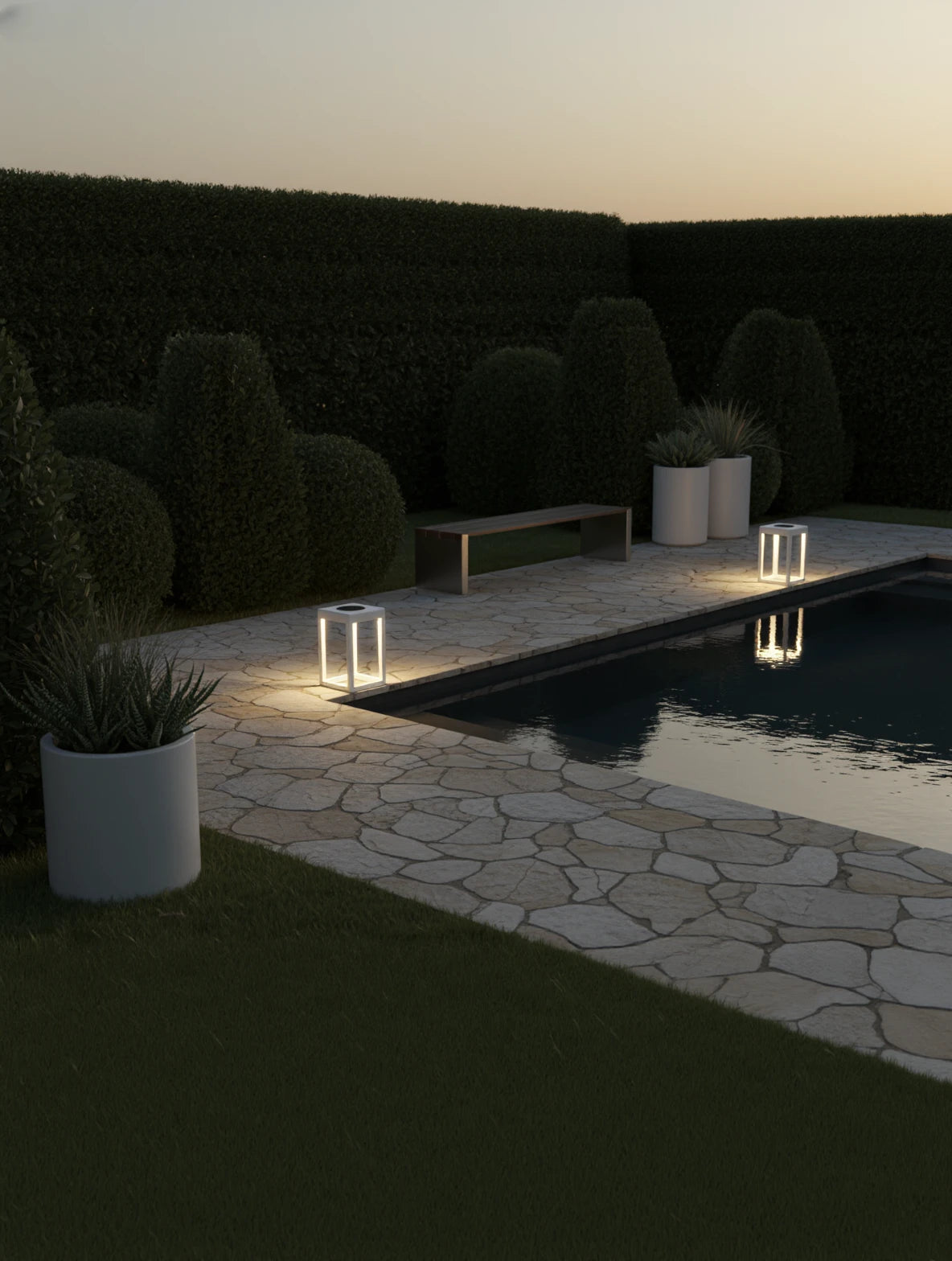 Kenya Solar Gartenlampe beleuchtet elegant angelegten Garten mit modernem, kubischen Design. Die warmen Lichtakzente reflektieren im Pool und betonen die stilvolle, minimalistische Atmosphäre.