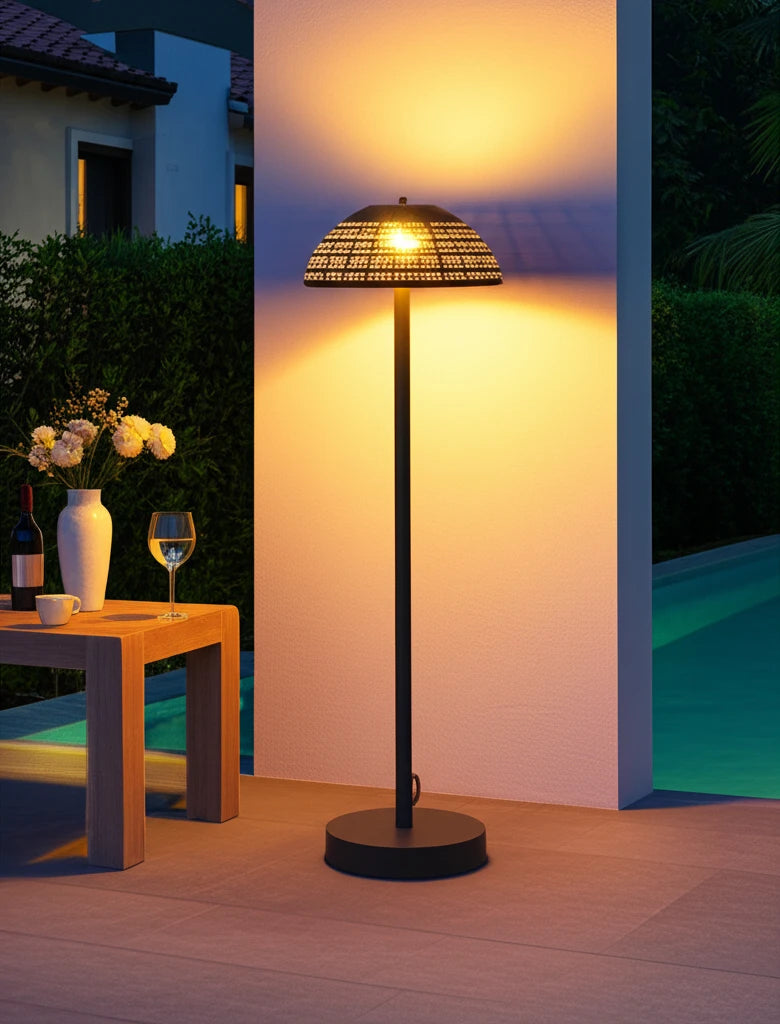 Kapalai Vertikale Lampe Aluminium Pulverbeschichtung Olefin-Taupe, eine elegante Solarleuchte auf der Terrasse, strahlt warmes Licht aus, ergänzt durch einen Tisch mit Blumen und Wein für entspannte Abende draußen.