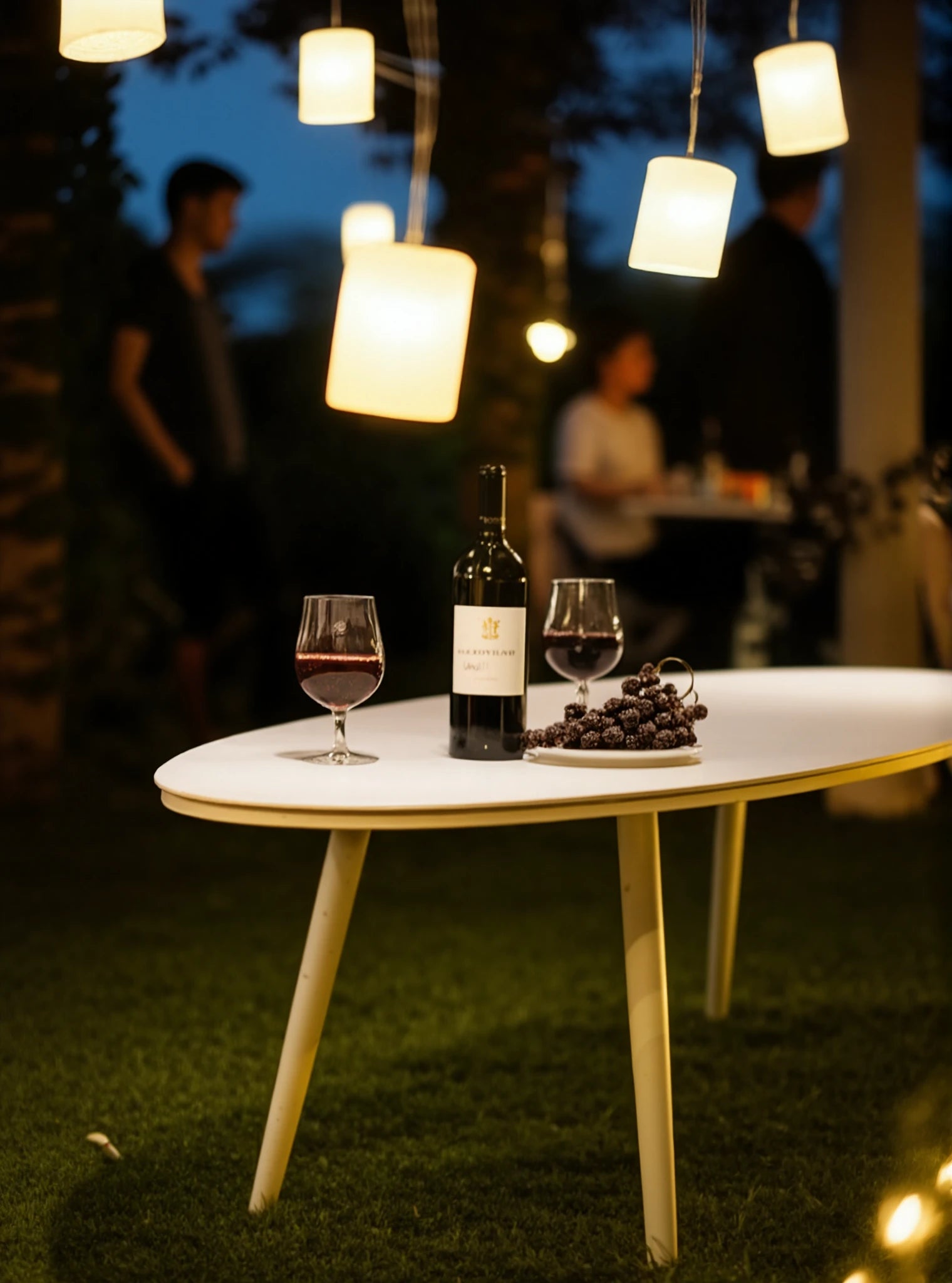 Freiburg Oval Boat Couchtisch aus Aluminiumlegierung mit Pulverbeschichtung, präsentiert mit Wein und Trauben unter Laternenlicht, betont langlebige, stilvolle Outdoor-Ästhetik von Finqa für gemütliche Abende.
