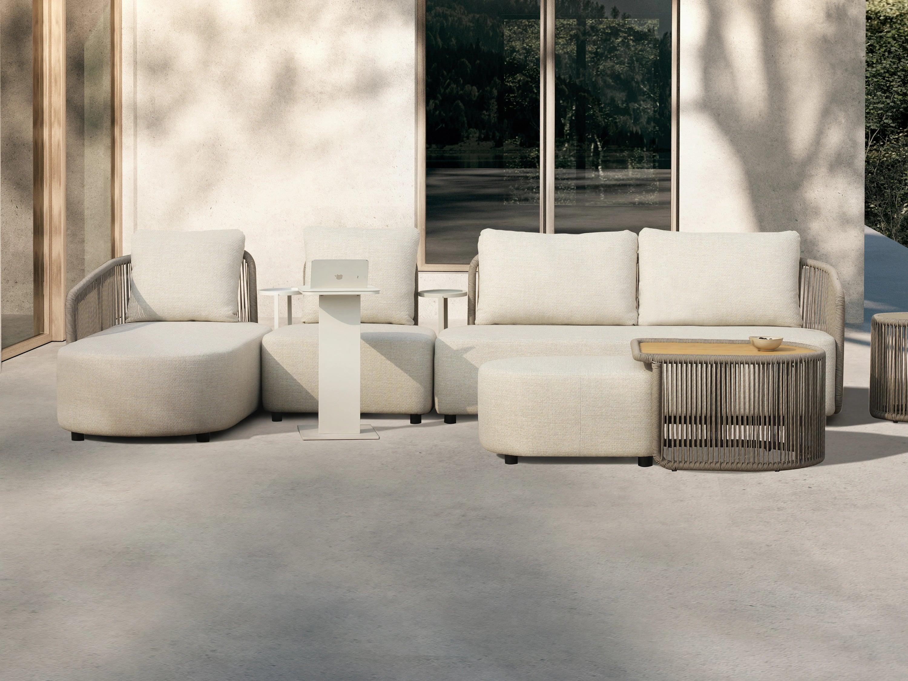 Kapalai Garten Loungesofa Set (5-Sitzer) auf einer Terrasse mit einem Couchtisch, zeigt geschwungene Linien und verleiht dem Outdoor-Bereich eine elegante, entspannende Atmosphäre. Perfekt für stilvolle Gartenmomente.