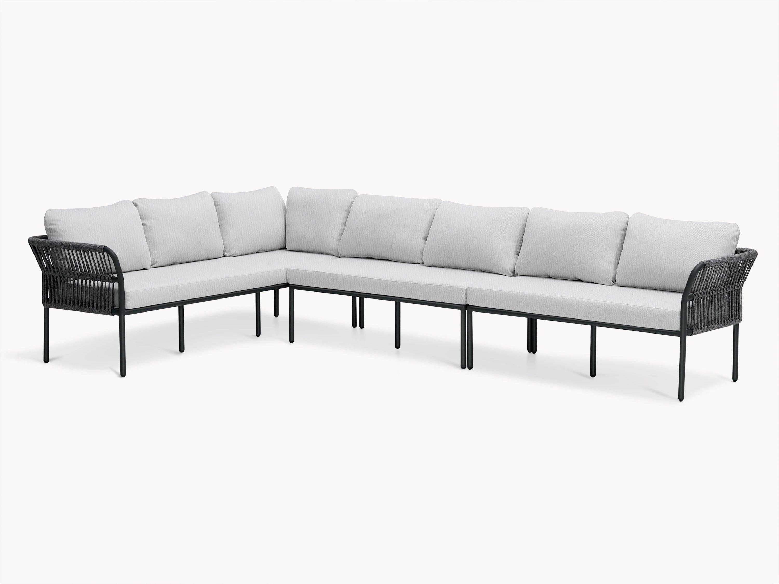 Malaga Garten Ecklounge Set (7-Sitzer) auf einer Terrasse, bestehend aus einem weißen Sofa mit schwarzen Beinen, zeigt robuste, wetterfeste Materialien und abgerundete Armlehnen für Komfort und Sicherheit.