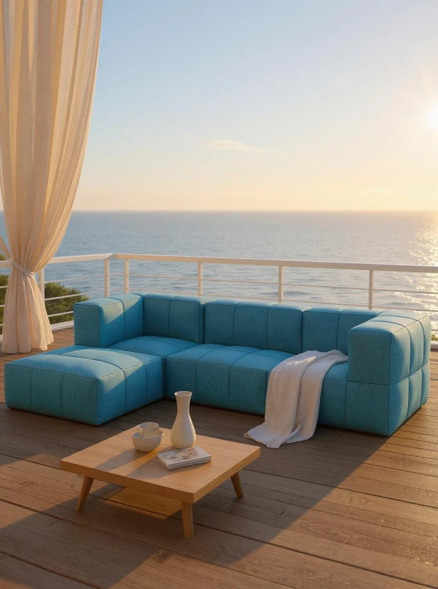 Babymax, 4er-Set (Copy): Auf einer Terrasse steht das modulare, türkisfarbene Finqa Marshmallow Sofa-Lounge-Set mit einem Holz-Couchtisch. Ideal für entspannte Momente mit Blick aufs Meer bei Sonnenuntergang.