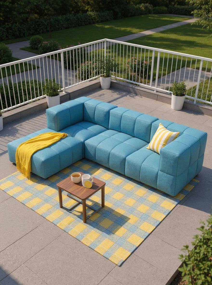 Babymax, 4er-Set (Copy): Modulares, himmelblaues L-förmiges Outdoor-Sofa mit gelbem Kissen und Decke, auf gewebtem Teppich, umgeben von Pflanzen, betont Komfort und Nachhaltigkeit für Terrasse oder Balkon.