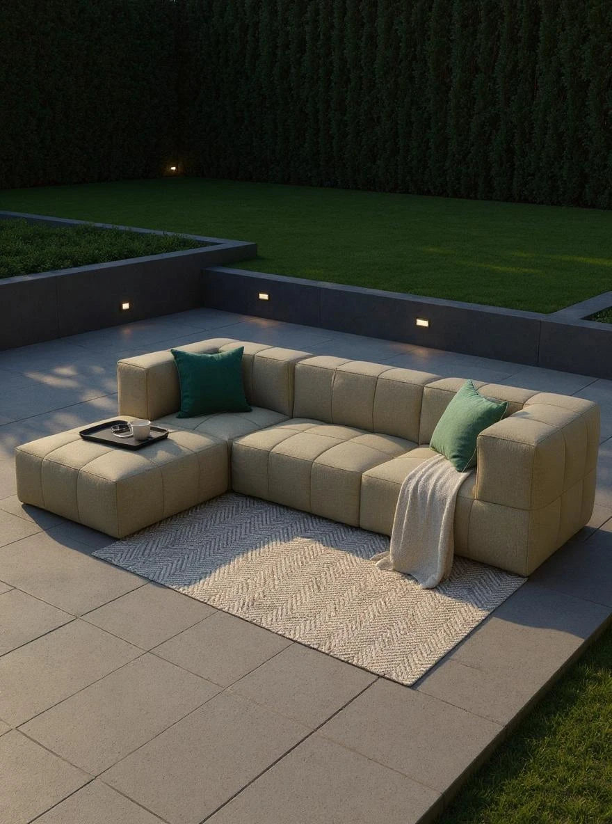 Marshmallow Modular Sofa Set (4-Sitzer) auf einem Sofa mit einem grünen Kissen, perfekt zum Entspannen. Nachhaltige Materialien und modulares Design bieten Komfort und Flexibilität für individuelle Gestaltung.