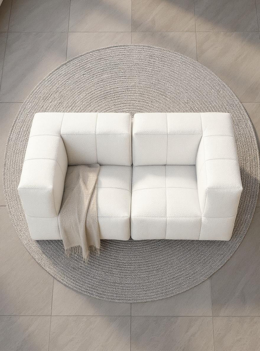 Finqa Marshmallow Modular Sofa Set S, ein stilvolles, modulares Sofa auf einem Teppich, inspiriert von Marshmallows, bietet durch recycelte Materialien Komfort, Flexibilität und Nachhaltigkeit für vielseitige Outdoor-Gestaltungen.