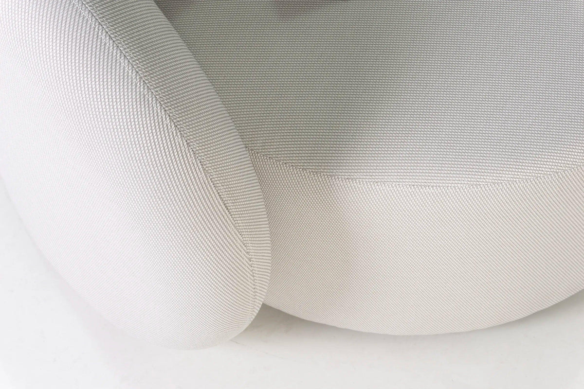 Nahaufnahme des Santorini Garten Loungesofa Set (8-Sitzer) mit strukturiertem, hellen Stoff und abgerundeter Naht, die den Übergang zwischen der runden Bolster-Kissen und dem Hauptkissen zeigt.