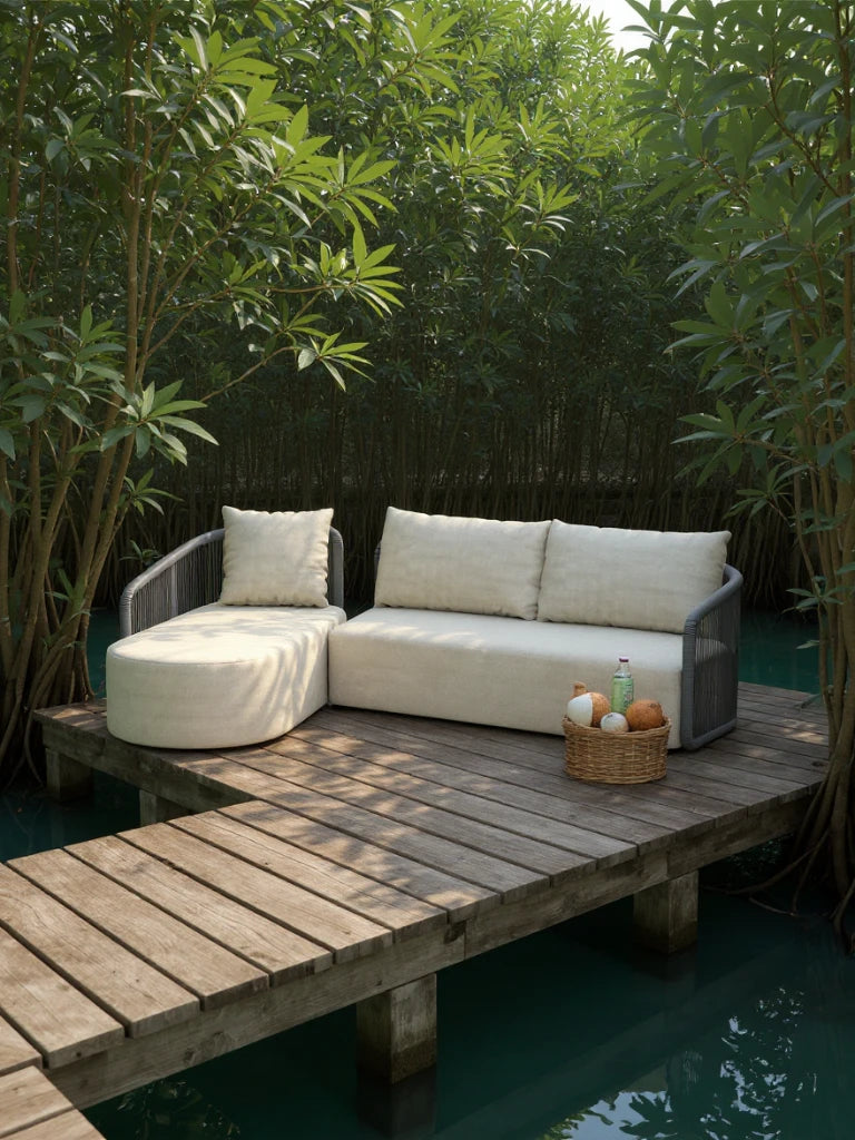 Kapalai Garten Loungesofa Set (4-Sitzer) auf einem Holzsteg: L-förmiges Sofa mit beigen Polstern, runder Ottomane, geflochtener Korb mit Kokosnüssen. Ideal für stilvolle, entspannte Outdoor-Momente.