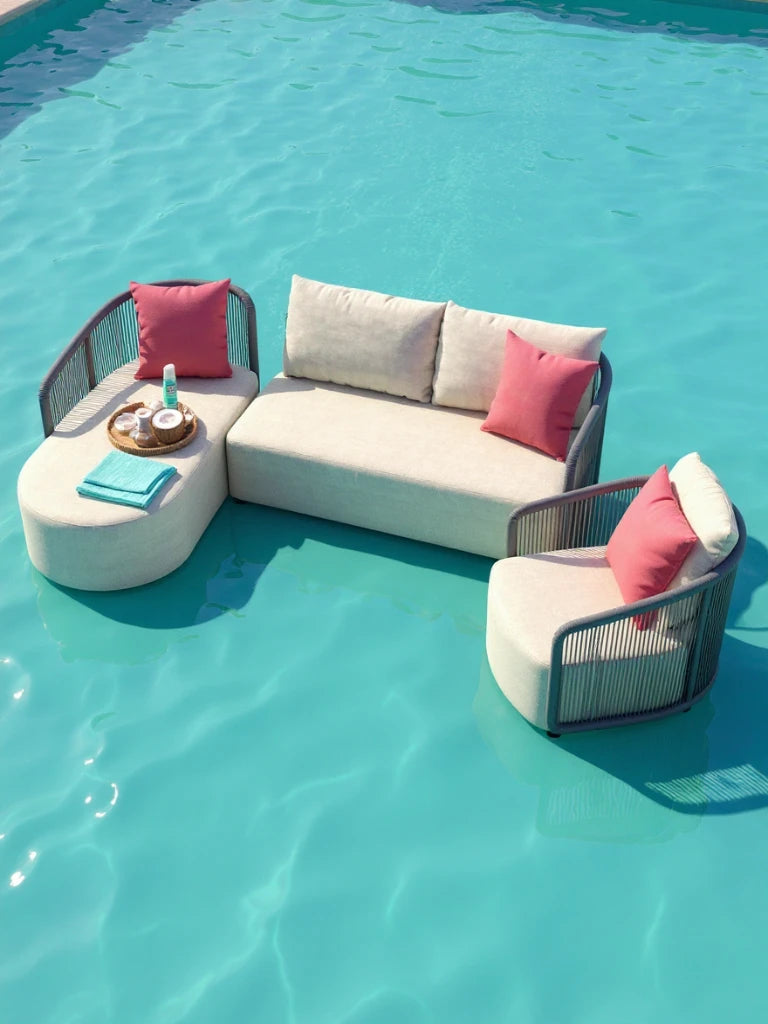 Kapalai Garten Loungesofa Set (5-Sitzer) schwebt modern auf einem Pool, mit lichtfarbenen Kissen und korallrosa Akzenten. Ottomane mit Tablett voller Spa-Artikel ergänzt das stilvolle Design.